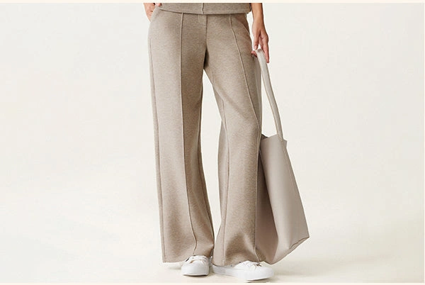 Straight-leg pants with front seam detailing, styled with sneakers.